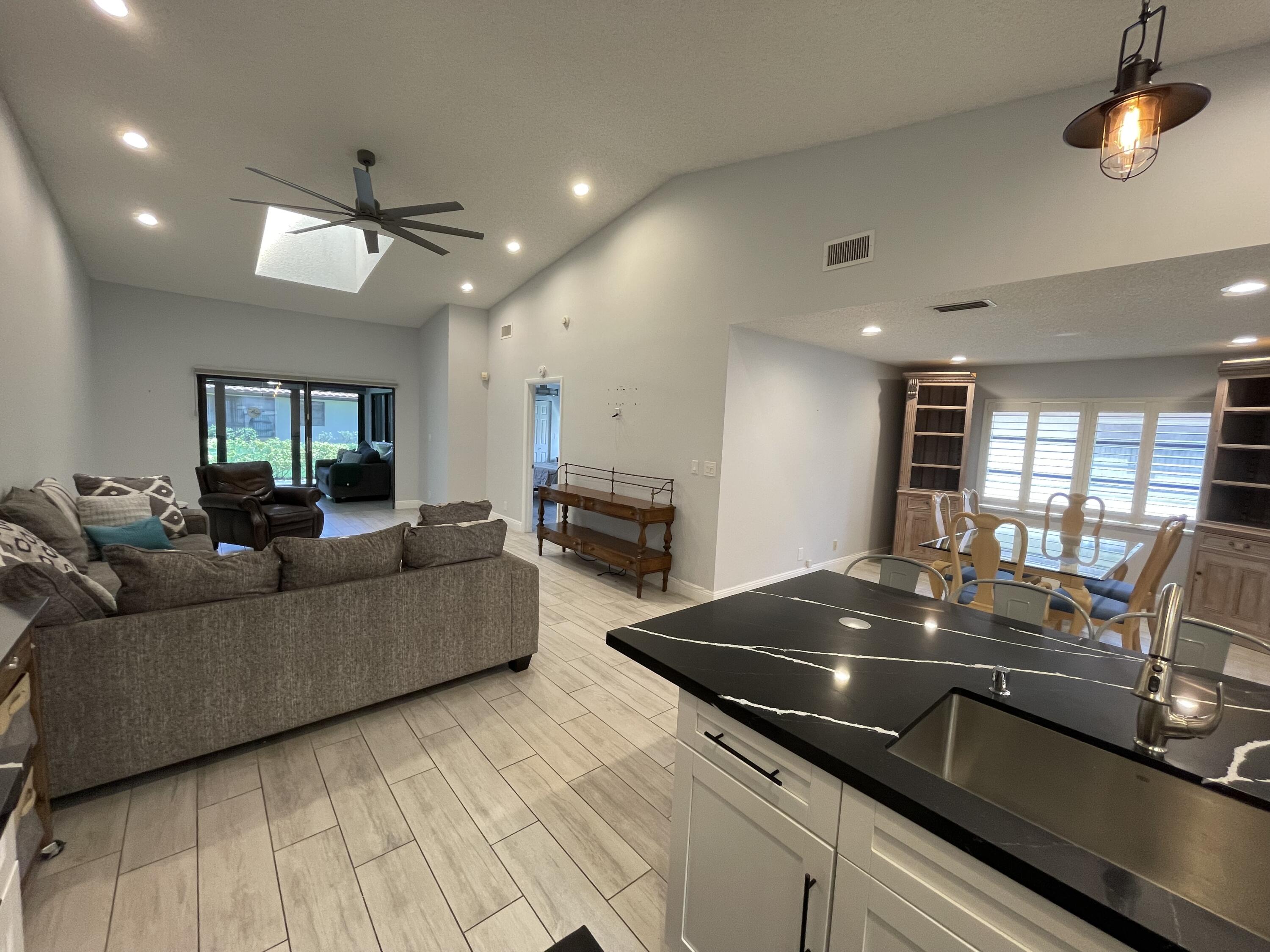6157 Sunny Pointe Circle Delray Beach, FL 33484 - Photo 7 of 64 a living room with furniture and kitchen view