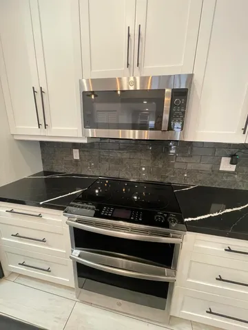 a kitchen with counter top space a sink and appliances