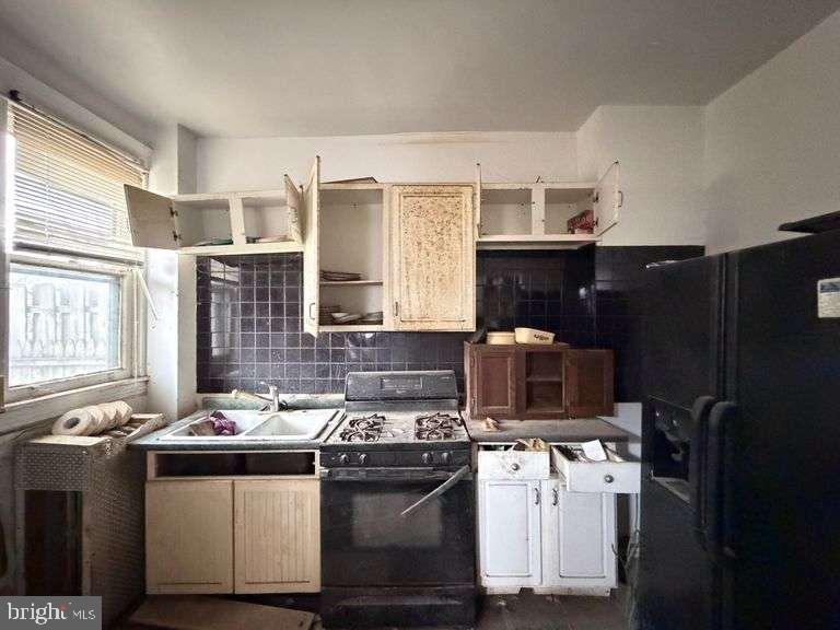 3923 Ridgewood Avenue Baltimore, MD 21215 - Photo 17 of 18 a kitchen with stainless steel appliances granite countertop a sink stove and refrigerator