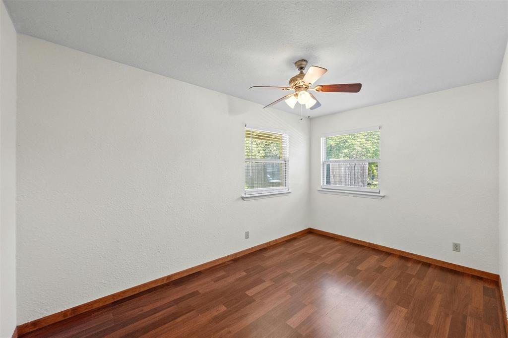 4610 South 1st Street Austin, TX 78745 - Photo 18 of 23 Empty room with baseboards, dark wood-style floors, and ceiling fan