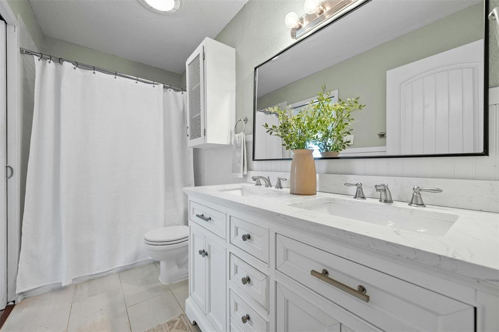 4610 South 1st Street Austin, TX 78745 - Photo 9 of 23 Full bath with toilet, double vanity, tile patterned flooring, and curtained shower