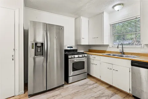 a kitchen with a refrigerator and white cabinets