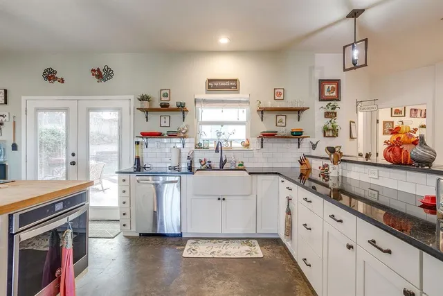 a kitchen with white cabinets and sink
