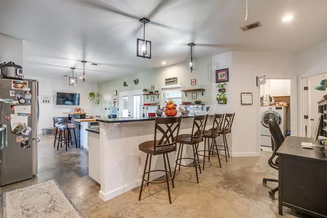 a kitchen that has a lot of cabinets in it and wooden floors