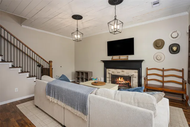 a view of a white house with a yard and lawn chairs under an umbrella