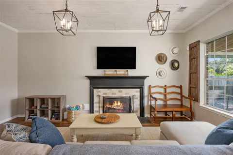 a living room with furniture a flat screen tv and a fireplace