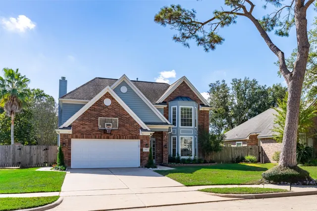 a kitchen with a refrigerator a stove top oven a sink dishwasher and white cabinets with wooden floor