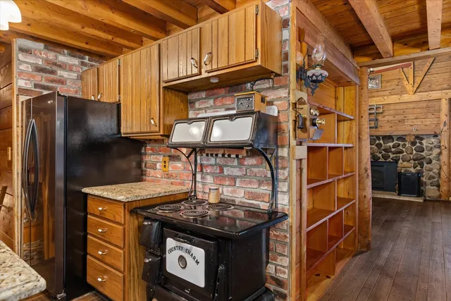 a kitchen with stainless steel appliances granite countertop a sink a stove and a wooden floor