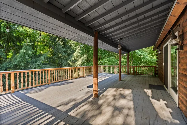 a view of backyard with a deck and wooden floor