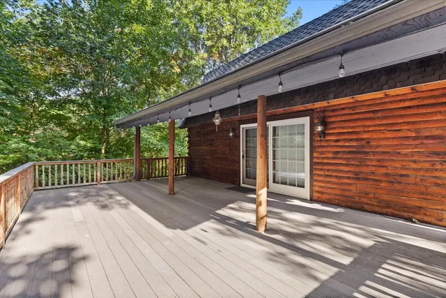 a view of backyard with wooden floor and fence