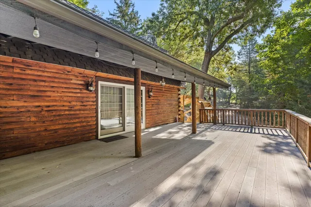 a view of a deck with a floor to ceiling window and wooden fence