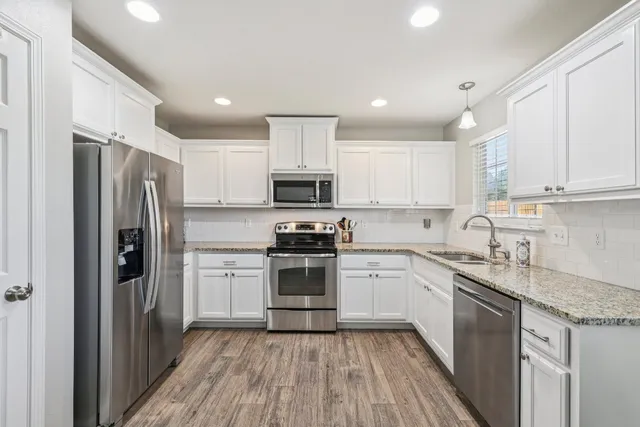 a kitchen with a sink stainless steel appliances and cabinets