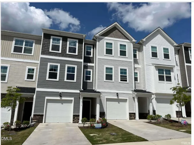 a front view of a residential apartment building with a yard