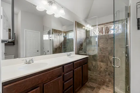 a spacious bathroom with a granite countertop sink and mirror
