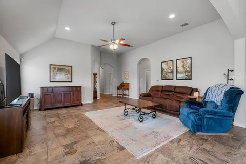 a living room with furniture a flat screen tv and kitchen view