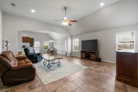 a living room with furniture and a dining table with kitchen view