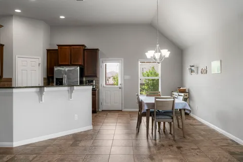 a kitchen with granite countertop a refrigerator and a stove top oven