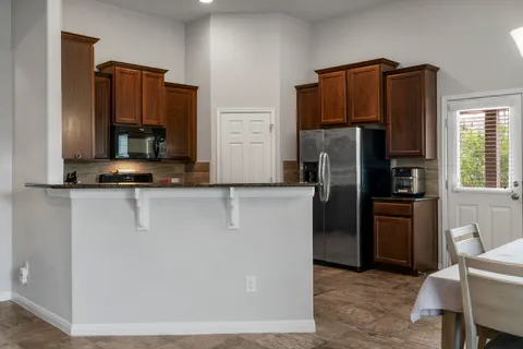 a kitchen with stainless steel appliances granite countertop a refrigerator stove and microwave