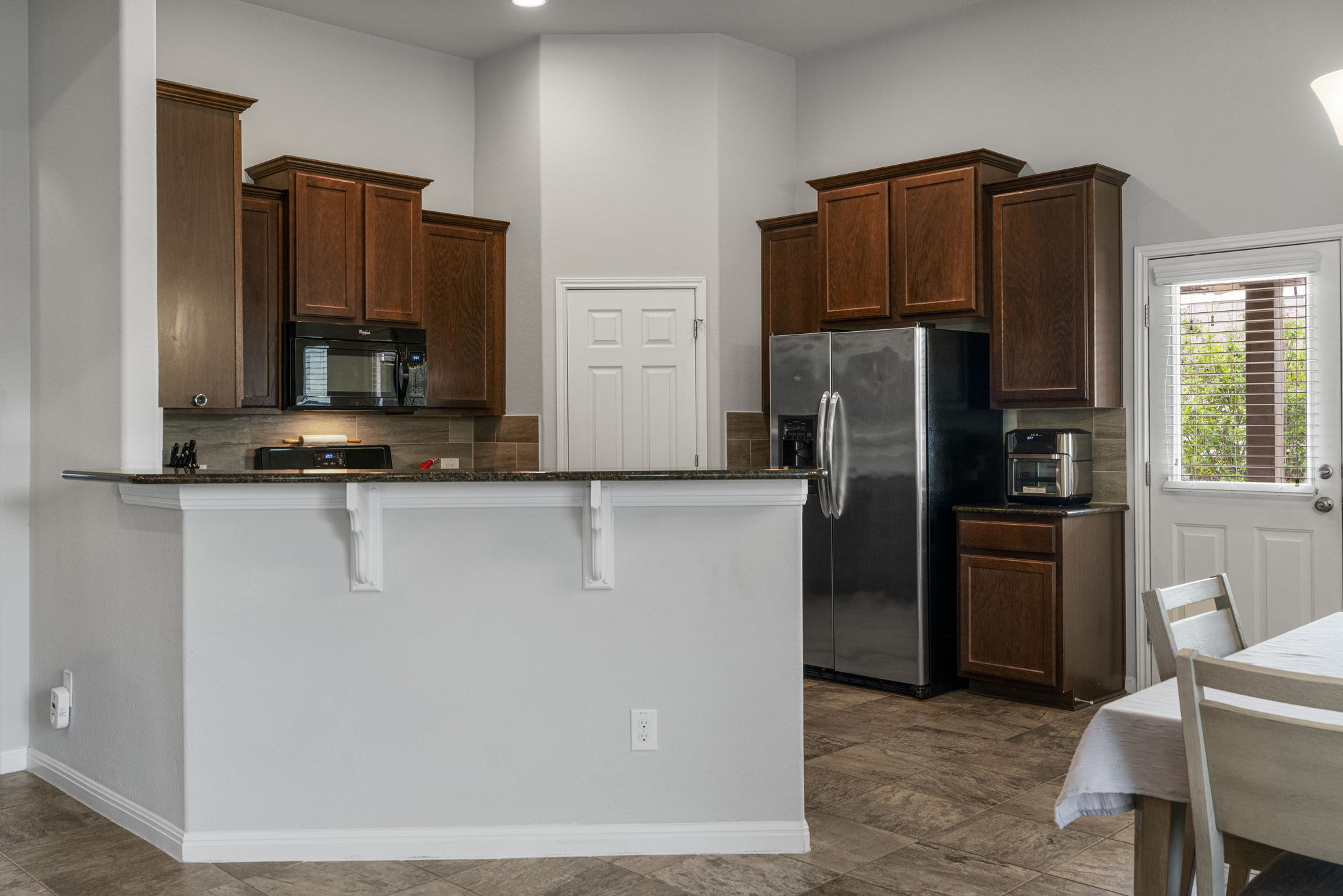 2009 Kates Cove Manchaca, TX 78652 - Photo 7 of 25 a kitchen with granite countertop a refrigerator and a stove top oven