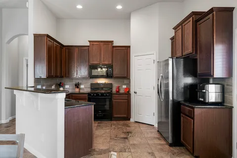 a living room with furniture a flat screen tv and kitchen view
