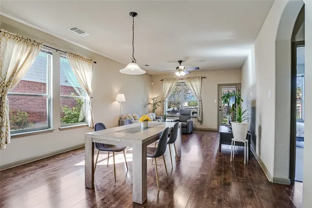 a view of a dining room and livingroom with furniture wooden floor a chandelier