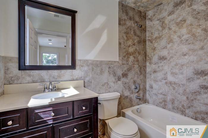 8 High Point Road East Brunswick, NJ 08816 - Photo 4 of 16 a bathroom with a sink a toilet and mirror