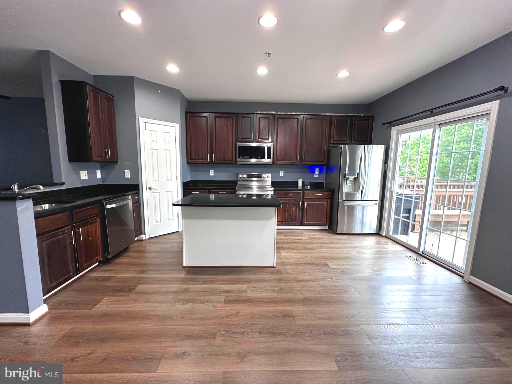 1427 Searchlight Way Mount Airy, MD 21771 - Photo 2 of 32 a large kitchen with stainless steel appliances granite countertop a stove top oven a sink dishwasher a refrigerator and a microwave oven on the wooden floor