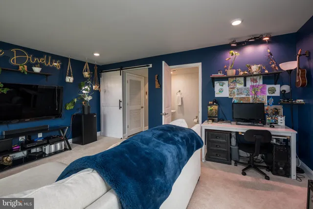 a living room with furniture a flat screen tv and kitchen view