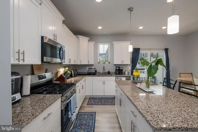 a kitchen with stainless steel appliances granite countertop a stove sink and cabinets