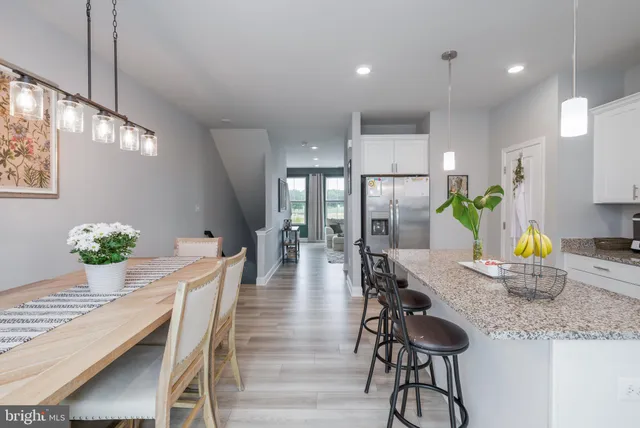 a kitchen with granite countertop kitchen island stainless steel appliances sink dining table and chairs