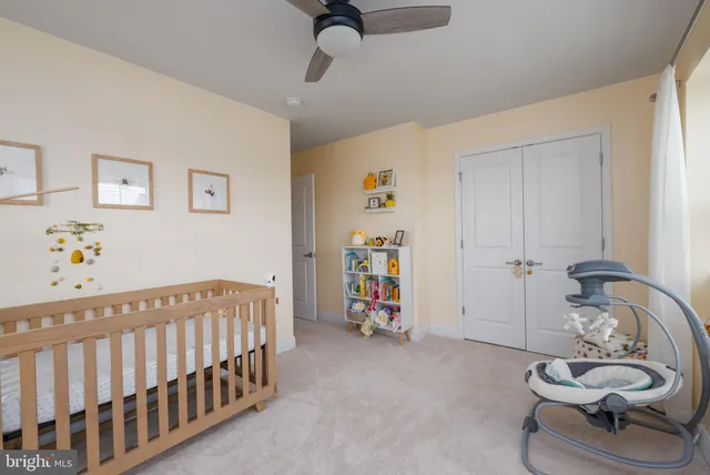a bedroom with a baby bed a couch and a window