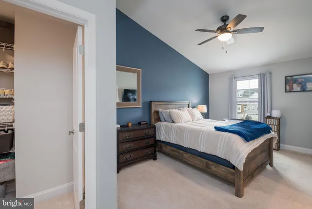 a spacious bedroom with a bed and a ceiling fan