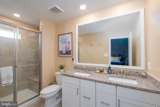 a bathroom with a granite countertop sink mirror and toilet