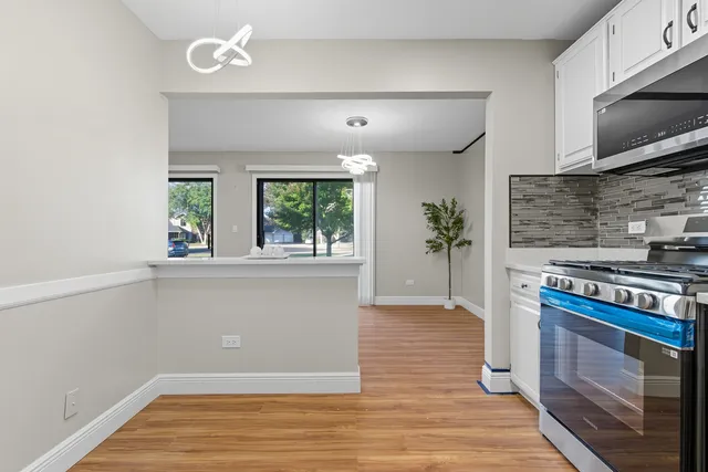 a kitchen with granite countertop a stove and a wooden floor