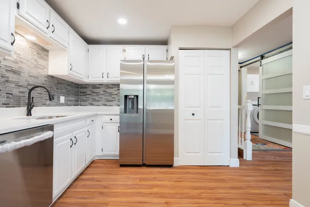 a kitchen with stainless steel appliances granite countertop a refrigerator and a sink