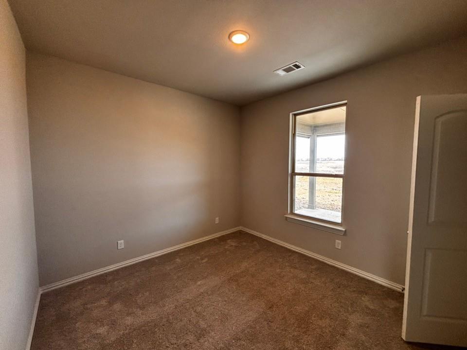 128 Pheasant Run Drive Rhome, TX 76078 - Photo 10 of 14 Neutral wall paint, plush carpet flooring, recessed ceiling lighting, and a window with exterior visibility
