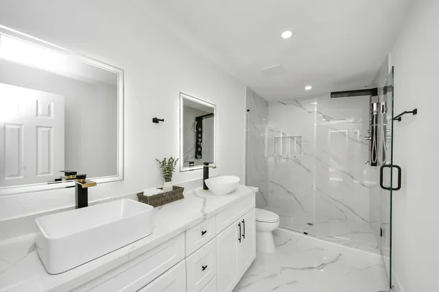 a bathroom with a double vanity sink toilet and shower