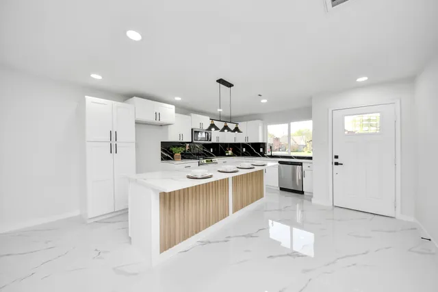 a kitchen with kitchen island a sink stainless steel appliances and cabinets