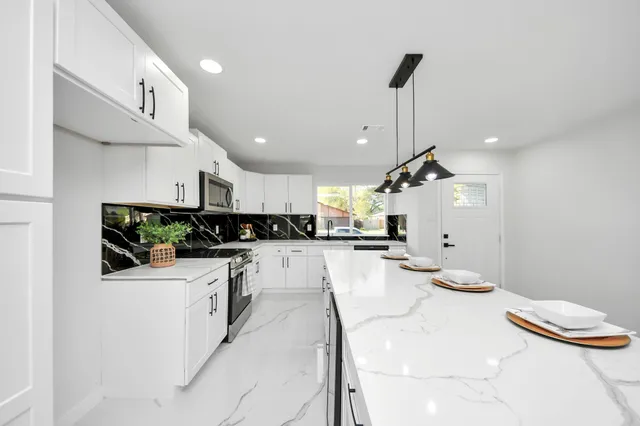 a kitchen with stainless steel appliances kitchen island granite countertop a sink and cabinets