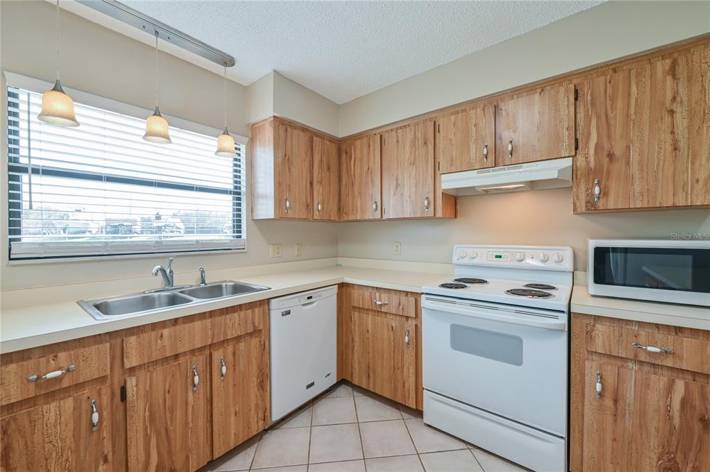 11001 Southeast Sunset Harbor Road, Unit H52 Summerfield, FL 34491 - Photo 22 of 31 a kitchen with cabinets appliances a sink and a window