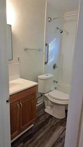 a bathroom with a sink a toilet and shower
