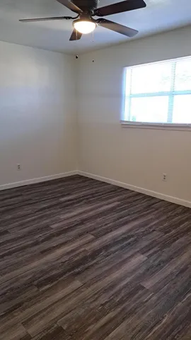 a view of a room with wooden floor and a window