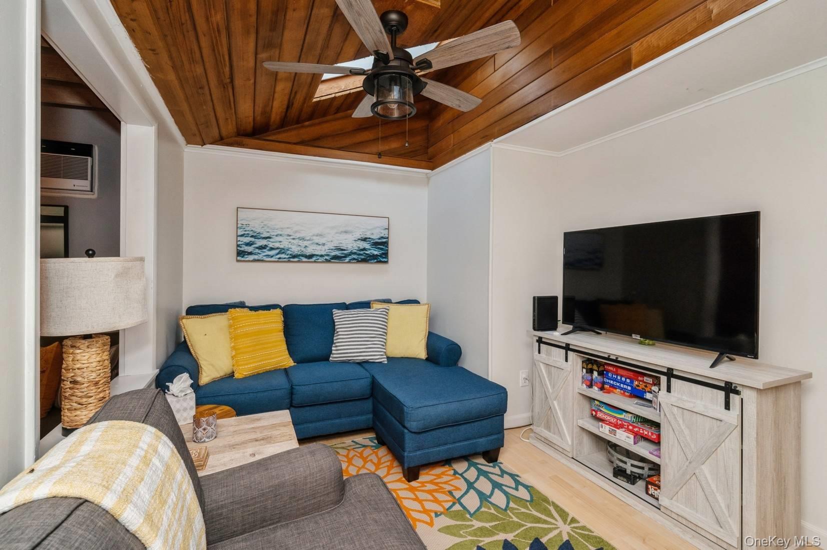 14 East Landing Road Hampton Bays, NY 11946 - Photo 21 of 25 a living room with furniture and a flat screen tv
