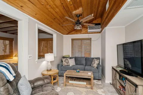 a living room with furniture a flat screen tv and a window