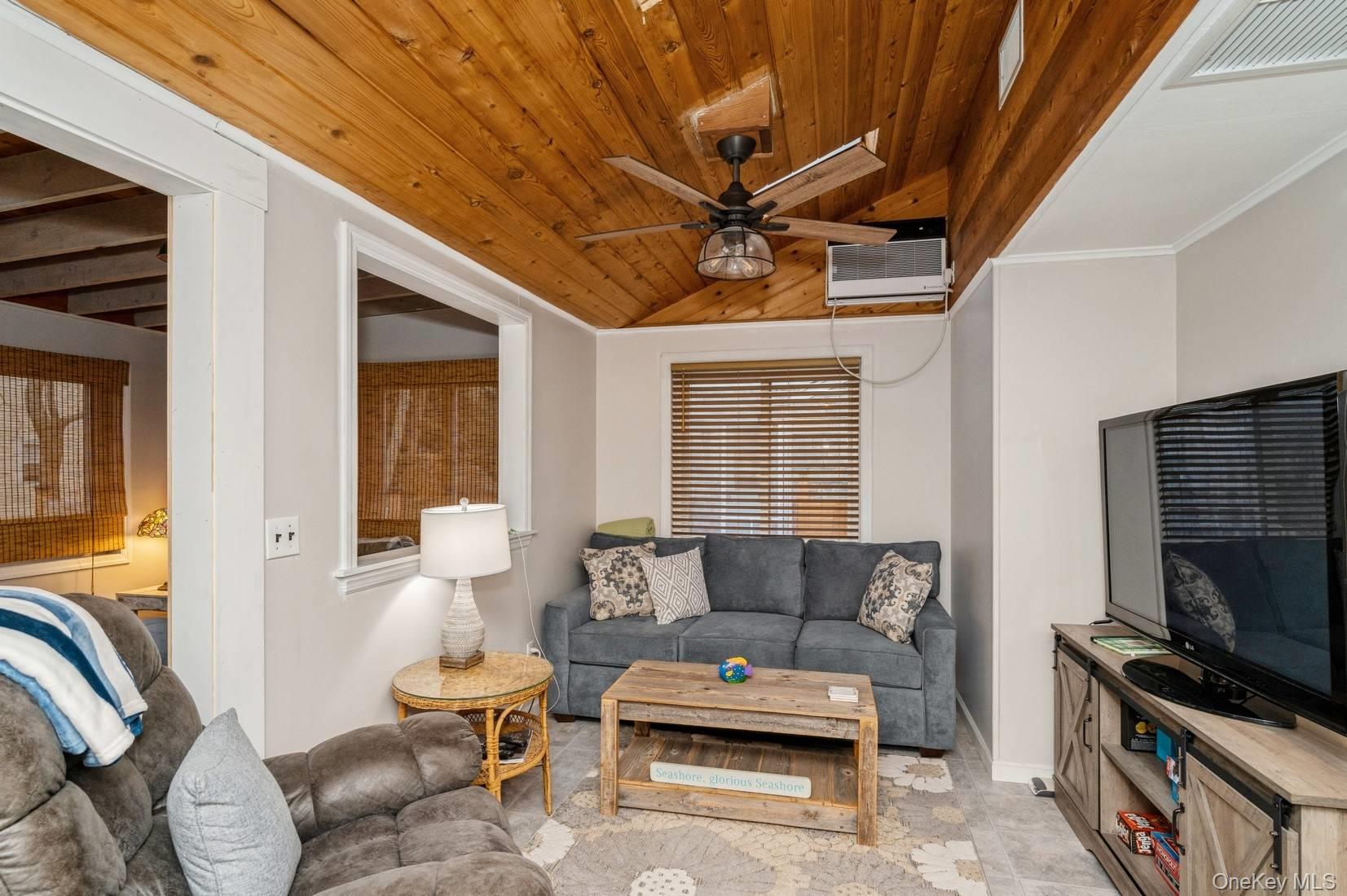 14 East Landing Road Hampton Bays, NY 11946 - Photo 22 of 25 a living room with furniture a flat screen tv and a window