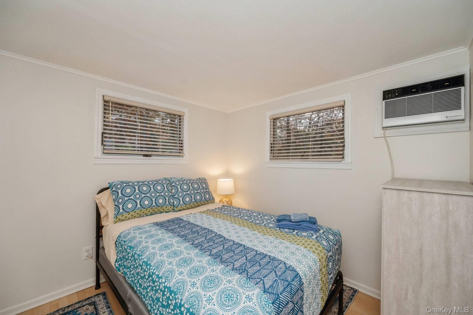 14 East Landing Road Hampton Bays, NY 11946 - Photo 8 of 25 a bedroom with a bed and wooden floor