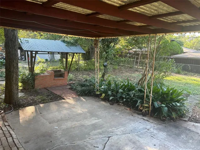 a backyard of a house with a fountain swing and table