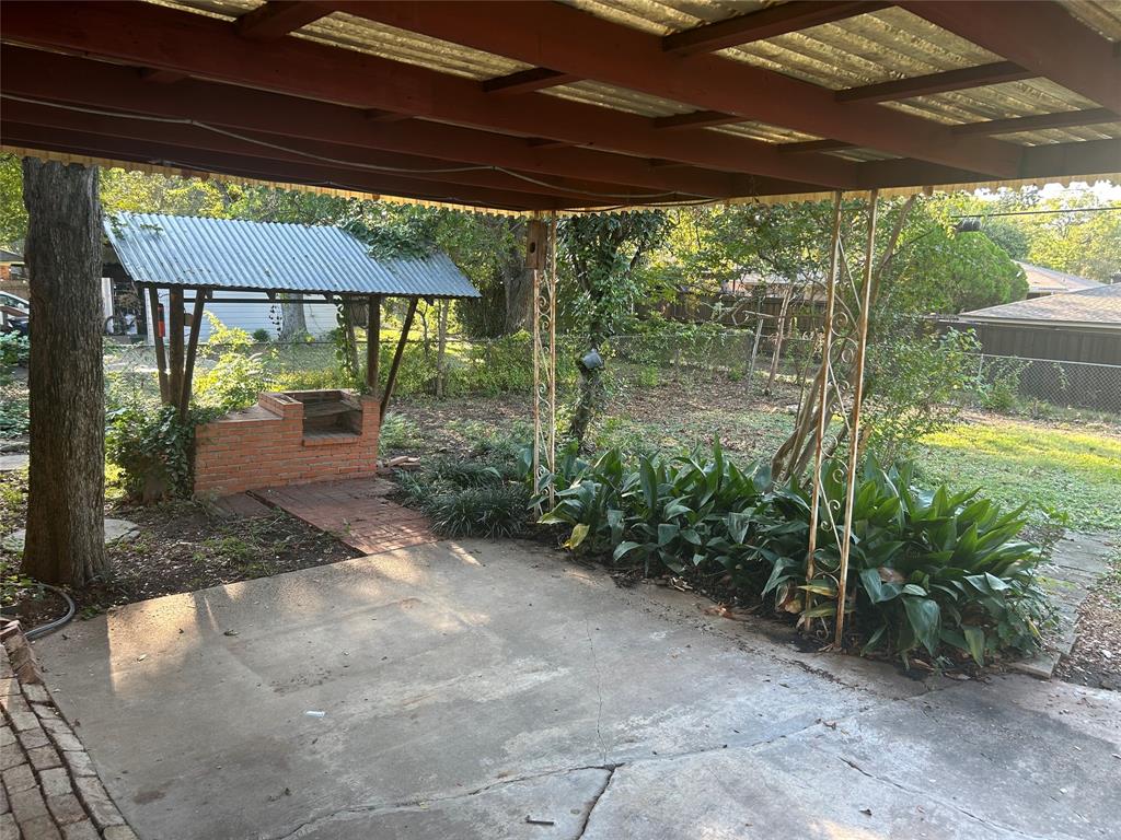 8051 Fall River Drive Dallas, TX 75228 - Photo 11 of 13 a backyard of a house with a fountain swing and table