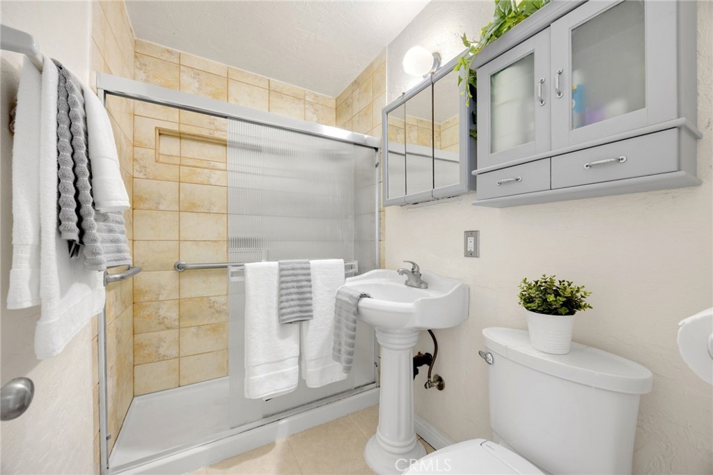 14721 Riata Street Midway City, CA 92655 - Photo 22 of 37 a bathroom with a sink a toilet and shower