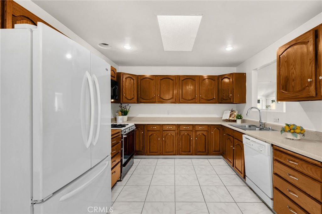 14721 Riata Street Midway City, CA 92655 - Photo 5 of 37 a kitchen with stainless steel appliances granite countertop a sink and cabinets